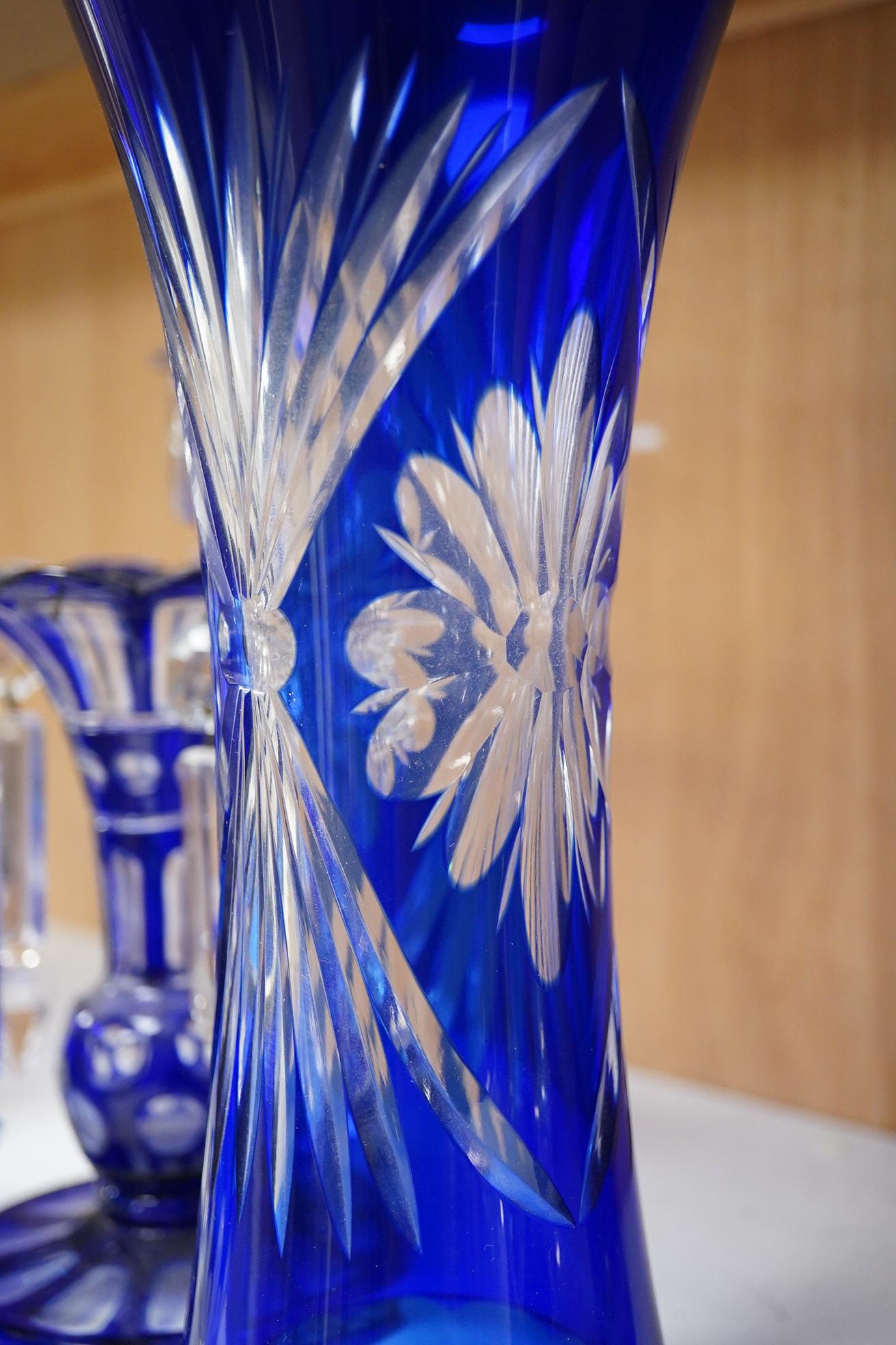 A pair of blue overlaid glass table lustres with drops and other blue overlaid glassware to include a pair of candlesticks and vases, largest 27cm high